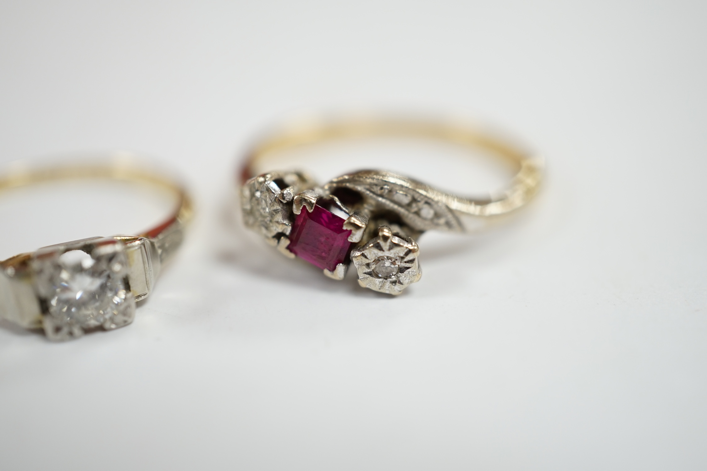 An 18ct, ruby and diamond chip set three stone crossover ring, size R and an 18ct, plat and solitaire diamond set ring, size N/O, gross weight 6.7 grams. Condition - fair